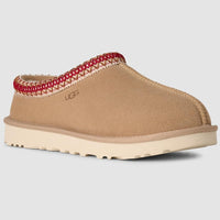 Tan slipper with red interior trim on a light gray background