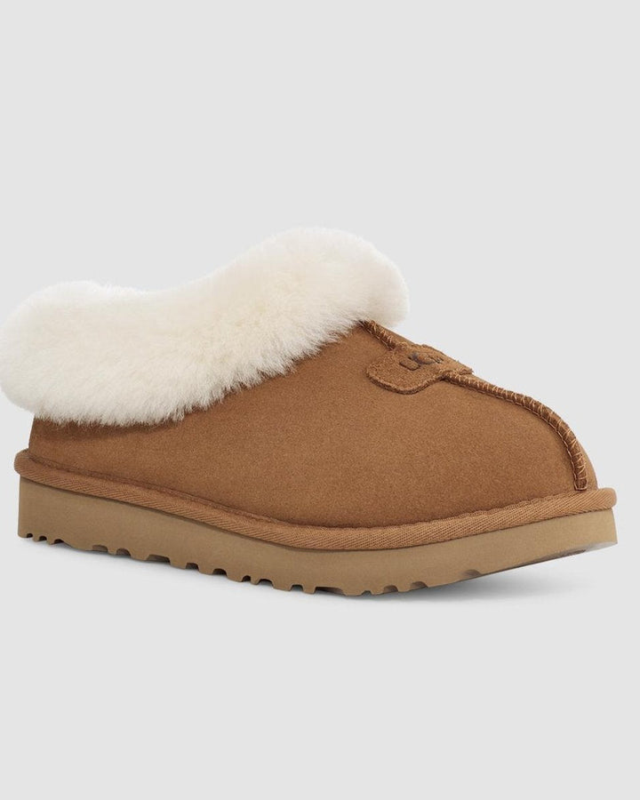 Brown slipper with white fur lining on a light gray background