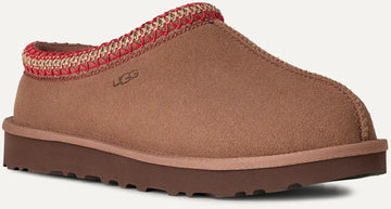 Brown UGG slipper with red interior on a white background