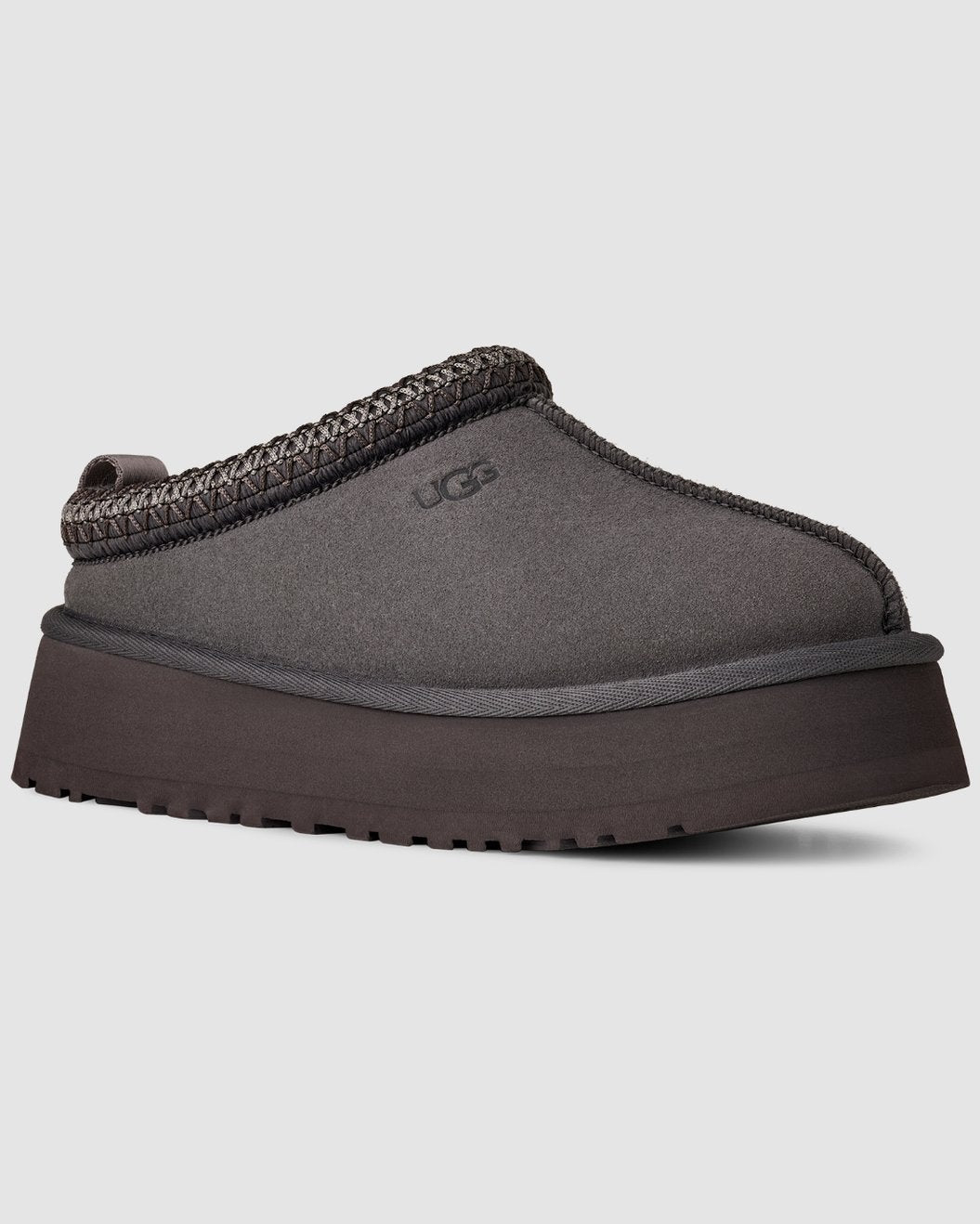 Gray UGG slipper with brown trim on a light gray background