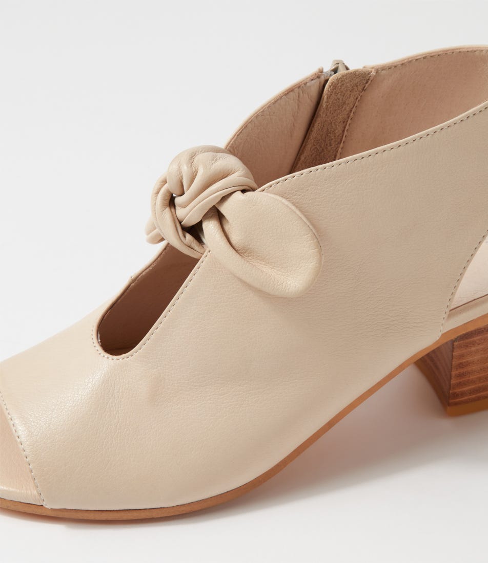 Beige shoe with a knot detail on a white background