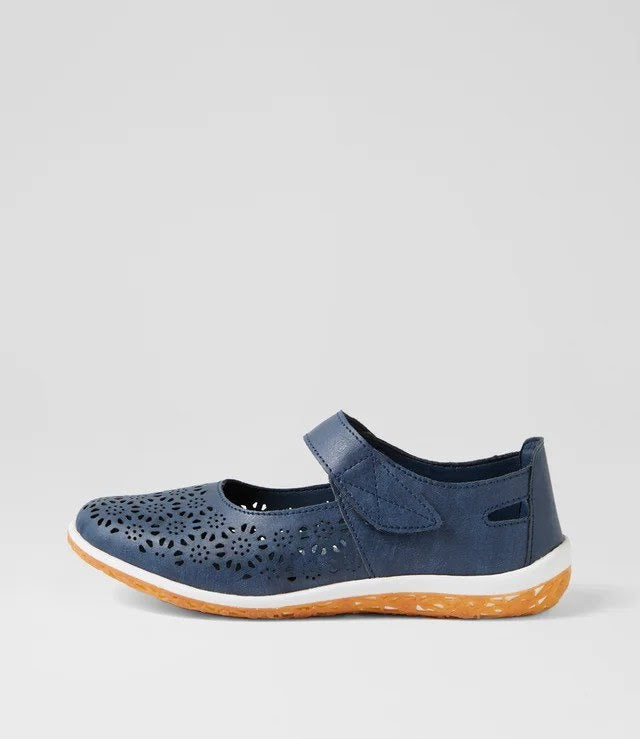A navy blue Mary Jane shoe with a perforated leather upper, hook-and-loop strap, and a white midsole with a textured orange outsole, shown against a light gray background.