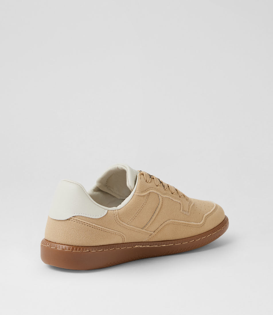 A low-top sneaker shown from a three-quarters rear angle, featuring a beige suede upper, a white heel tab, and a brown gum sole, set against a plain light gray background.