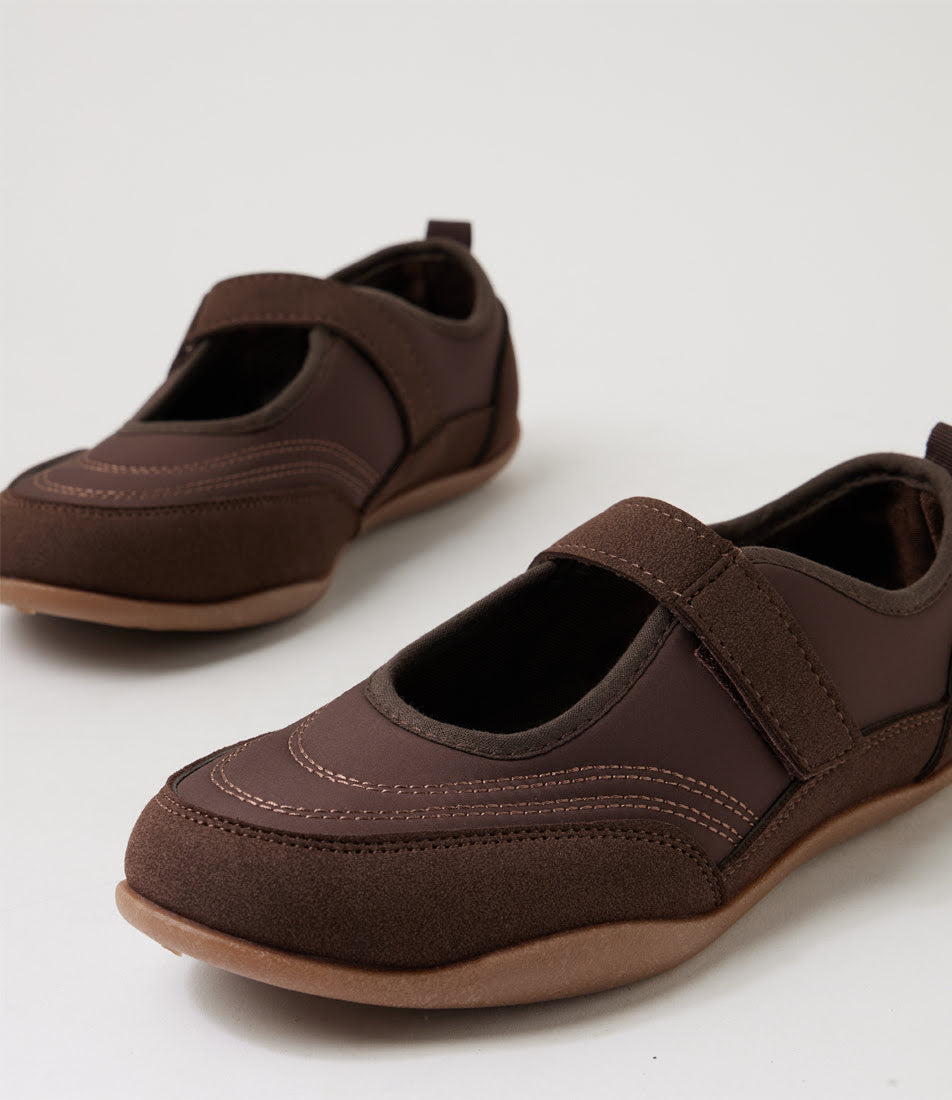 A pair of dark brown slip-on shoes with hook-and-loop straps and tan soles, photographed on a clean white studio background.
