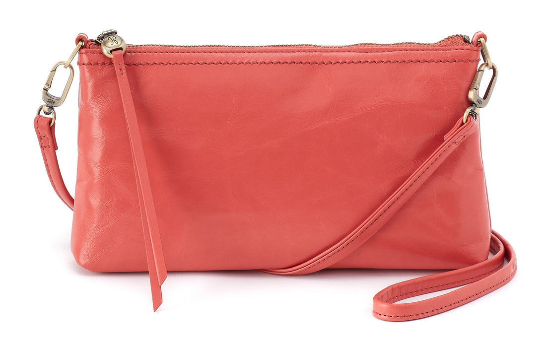 Pink leather crossbody bag with a strap on a white background