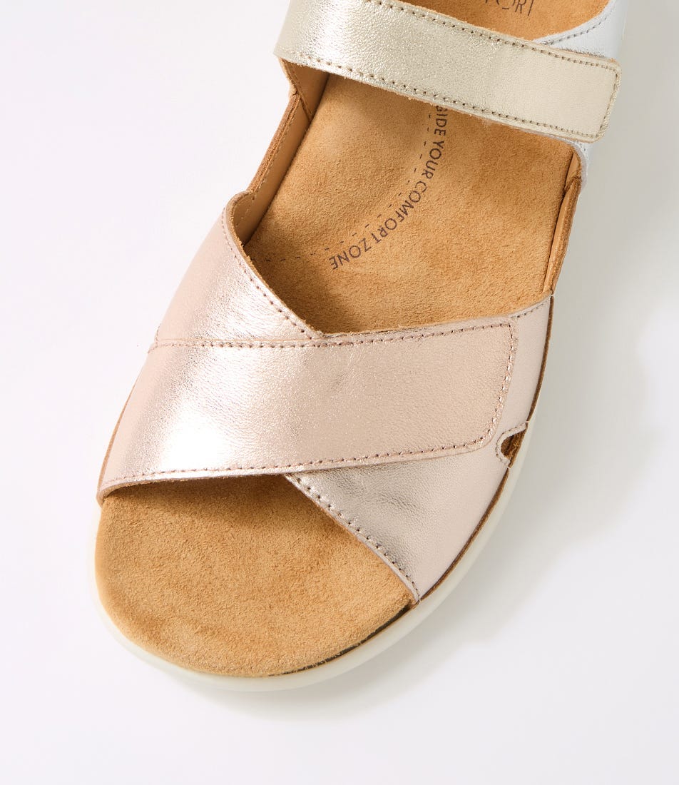 Close-up of a sandal with metallic pink and brown straps on a white background
