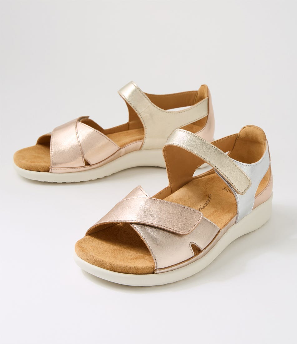 Pair of rose gold sandals with beige soles on a light gray background
