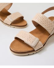 Ziera Kift wedge sandal in natural-toned raffia with adjustable straps, cushioned footbed, and mid-height wedge sole on a white background